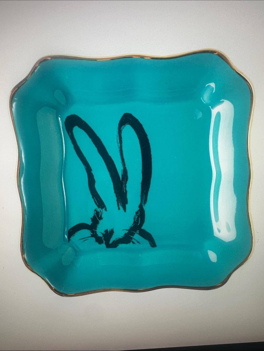 Hunt Slonem whimsical bunny, teal dish trimmed in gold.